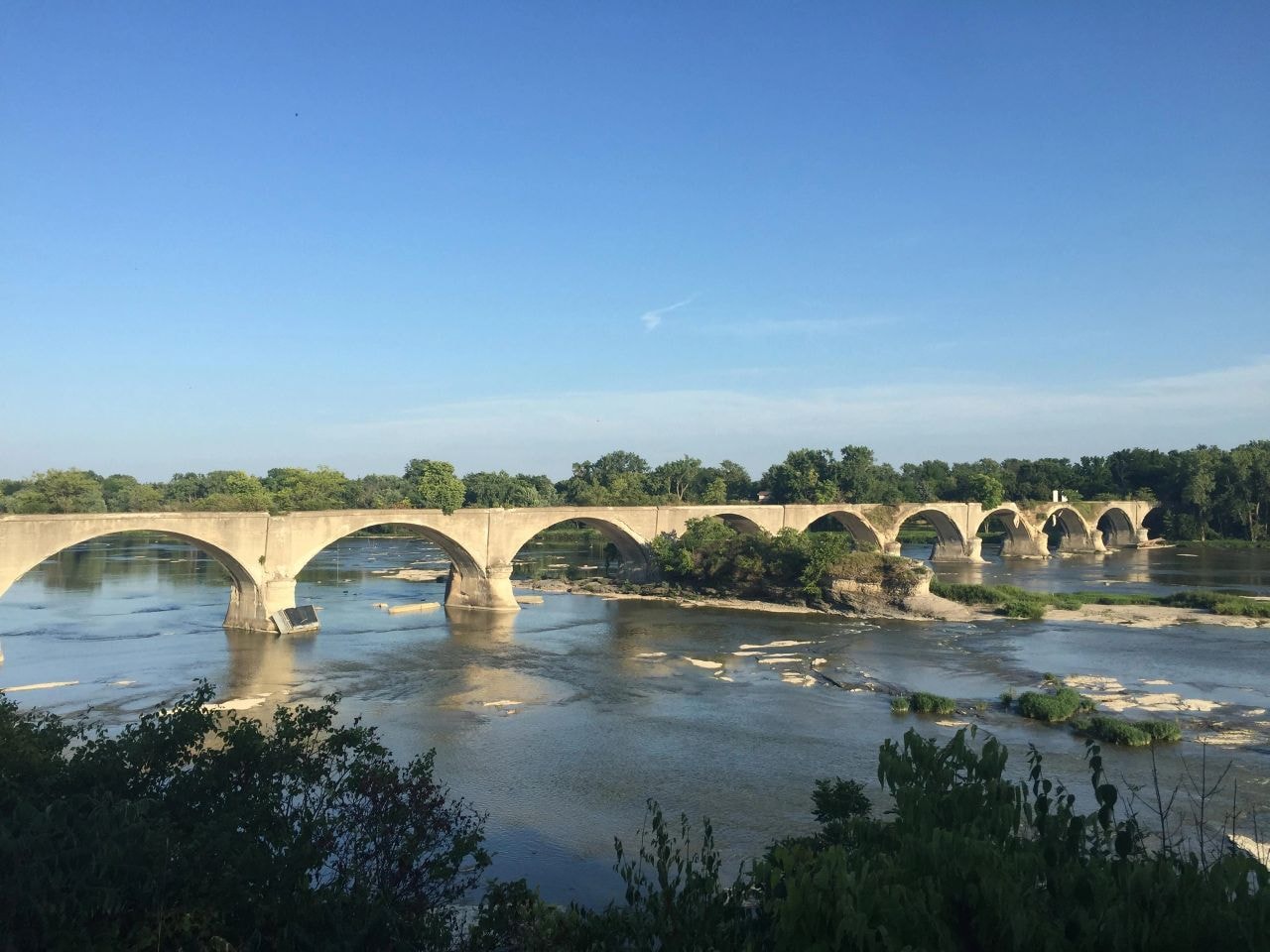 Full view of the Interurban Bridge spanning the Maumee River on a clear summer day, all arches visible